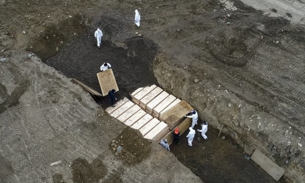 Наемные рабочие в защитных костюмах хоронят людей на острове Харт, Нью-Йорк