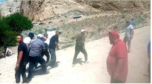 Жители уносят раненого из зоны обстрела