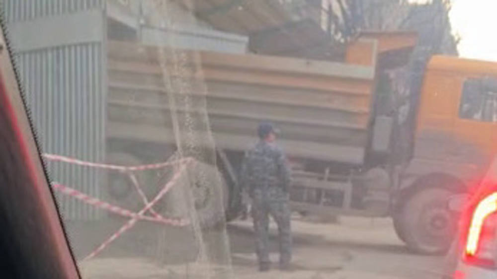 Грузовик с грязными колесами выезжает со стройки на дорогу. Видео