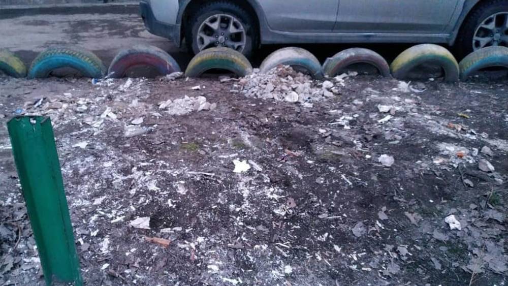 Горожанин складирует строймусор во дворе дома. Фото