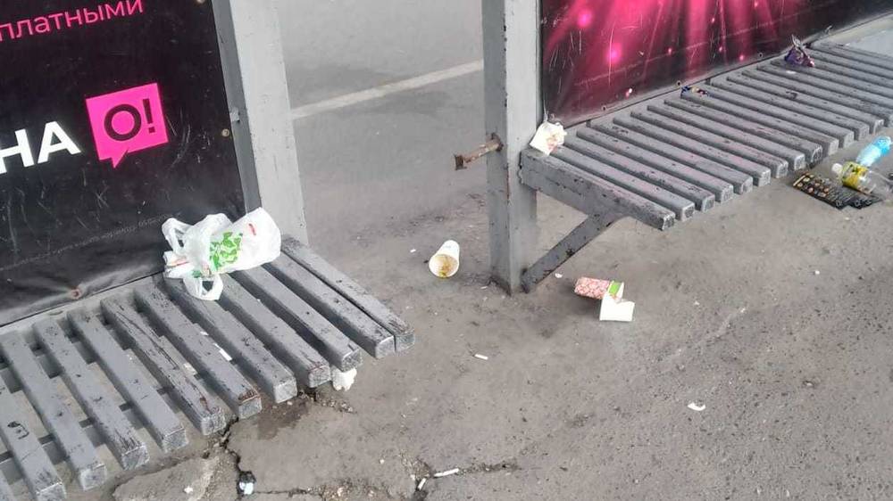 На остановке на Советской нет урны, мусор валяется на скамейке. Фото