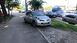 Зеленую зону на Льва Толстого превратили в стоянку сломанных авто. Фото