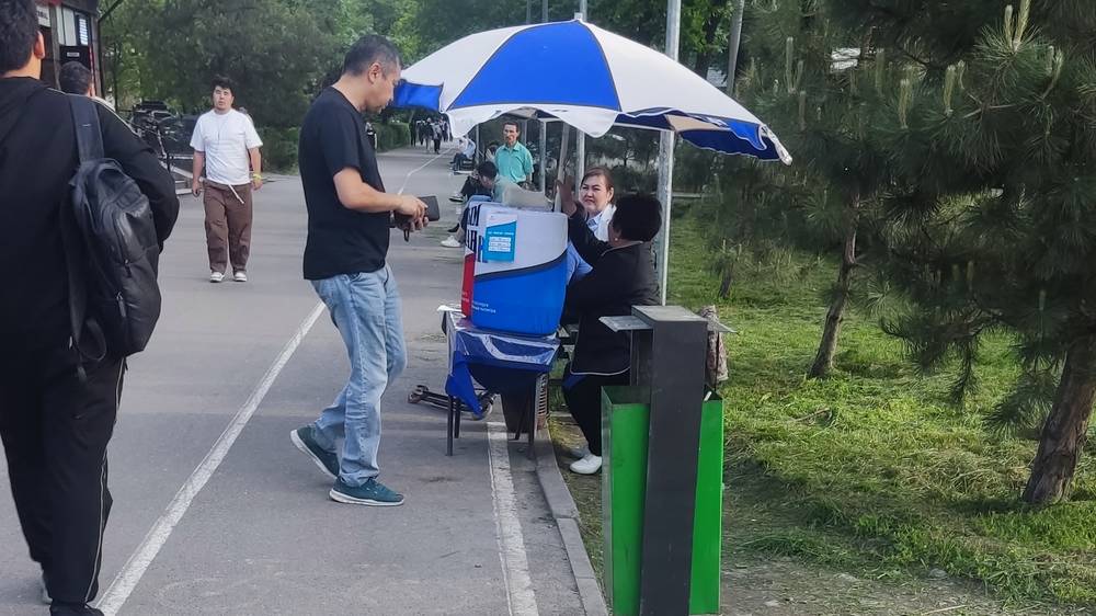 Продавщица «Тана» сидит на велодорожке по Манаса. Фото