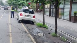 Зеленая зона и велодорожка на Токтогула заставлена машинами, рядом стоит патрульный. Фото