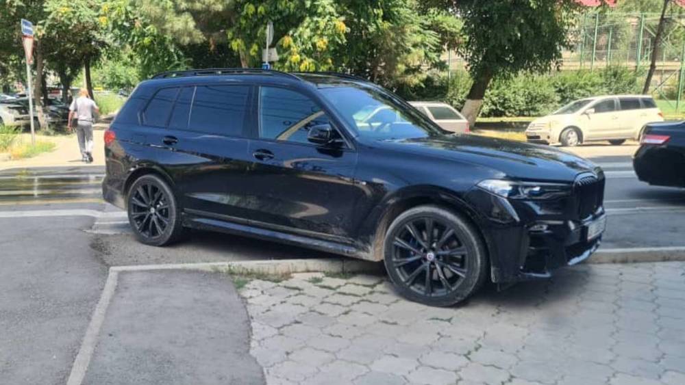 BMW X7 стоит на тротуаре. Фото