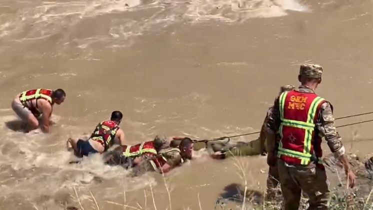 Спасатели МЧС извлекают из реки тело погибшего человека