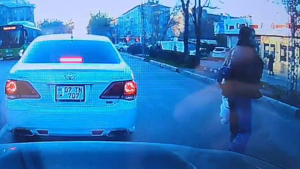Женщина переходила дорогу в неположенном месте и едва не попала под колеса. Видео