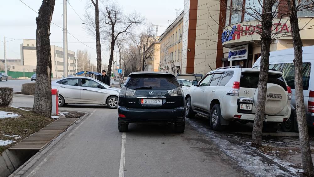 На Айтматова водители снова массово паркуются на тротуаре и велодорожке. Фото