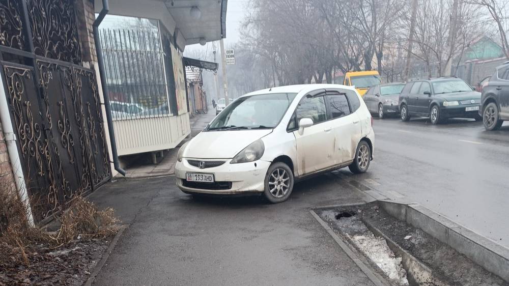 «Фит» со штрафами 6600 сомов стоит на тротуаре. Фото