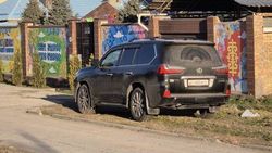 Lexus LX 570 стоит в зеленой зоне возле детского сада. Фото