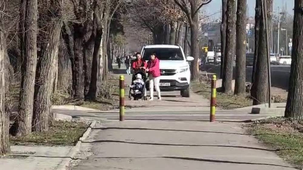 Корейский внедорожник едет по тротуару на Айтматова, мешая женщине с коляской. Видео