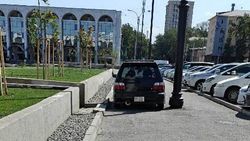 Машина едет по тротуару на площади Ала-Тоо. Фото