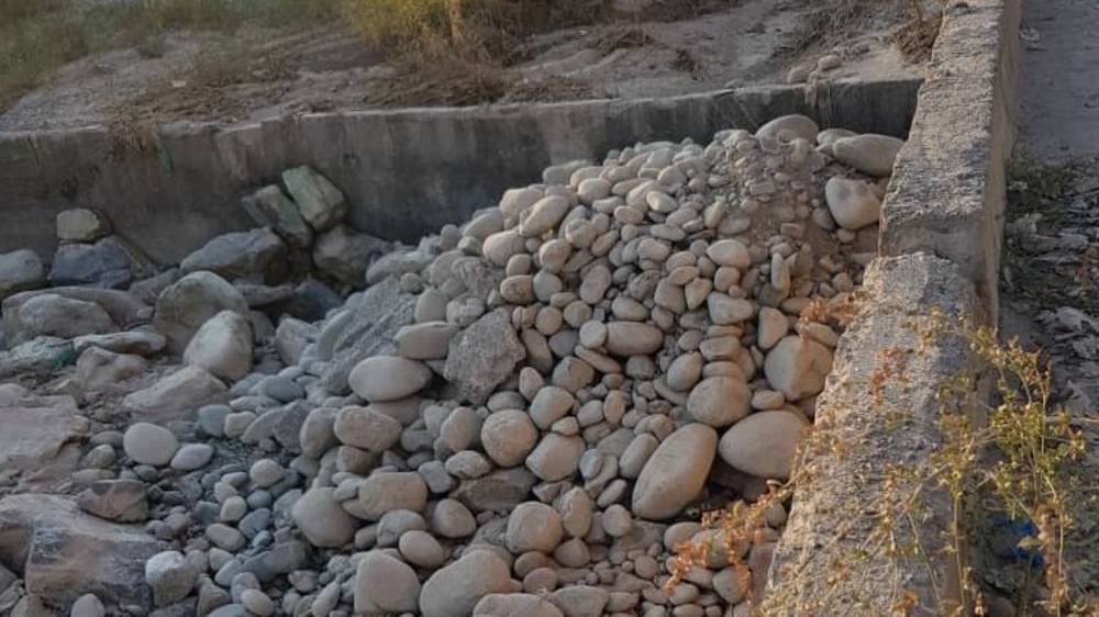 В 6 мкр в русло реки вываливают камни. Фото