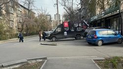 Бус стоит на тротуаре на Сыдыкова, люди ходят по дороге. Фото