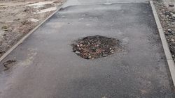 На Фрунзе—Суюмбаева яма на тротуаре, на газоне торчит длинная арматура