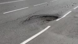 Глубокую яму на новом асфальте на улице Фучика заделают при потеплении