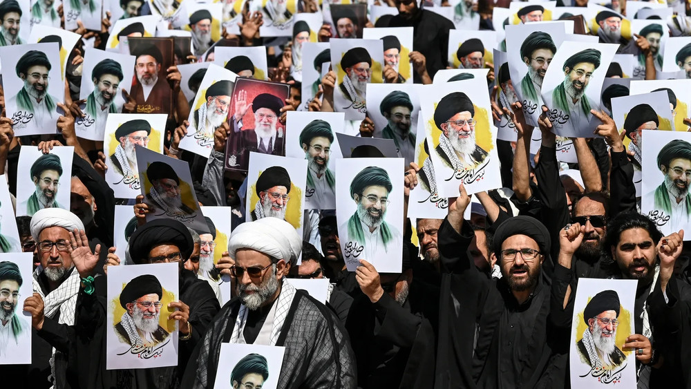 Мусульмане-шииты держат портреты убитого верховного лидера Ирана Али Хаменеи и его сына и преемника Моджтабы Хаменеи во время процессии в 