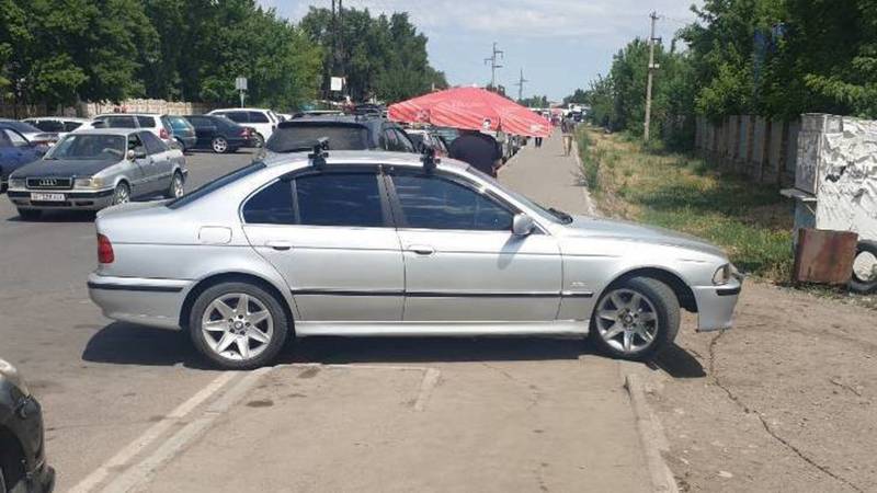 BMW 523 припаркован на тротуаре. Фото