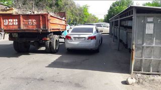 Машина припарковалась рядом с мусорными баками, создав помеху мусоровозу