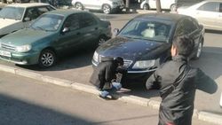 Возле дома правительства парень поменял госномер авто на поддельный. Фото очевидца