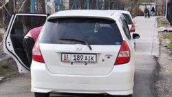 Два белых «Фита» припарковались на аллее. Фото