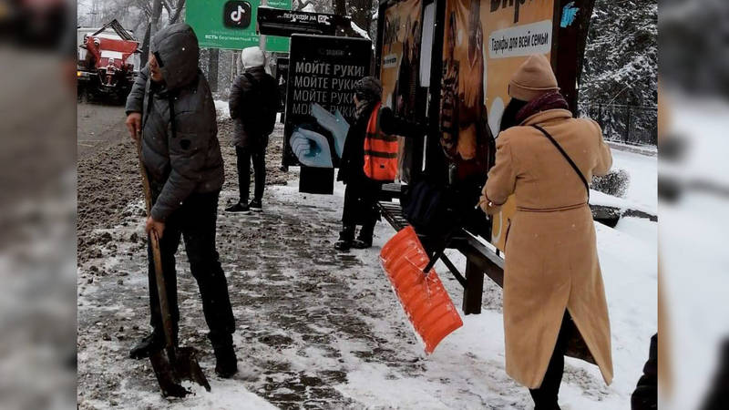 Прохожие помогают убирать снег работнице «Тазалыка». Фото