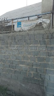 В селе Чон-Арык на заборе дома висит порванный баннер партии СДПК (фото)