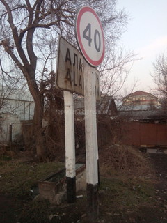 Дорожный знак с указанием населенного пункта при въезде в Аламедин закрывает знак ограничения скорости движение (фото)